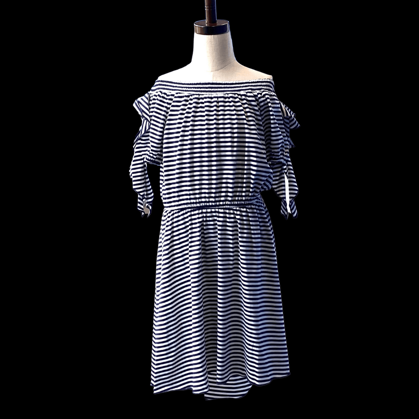 A flawless and easy high low dress that can be dressed up or worn as is for a trendy, casual look. Details include off-the-shoulder sleeves with faux tie detail, elastic shoulder band, elastic waistband, and a beautiful draped hem. This dress comes in a soft, high quality jersey knit.