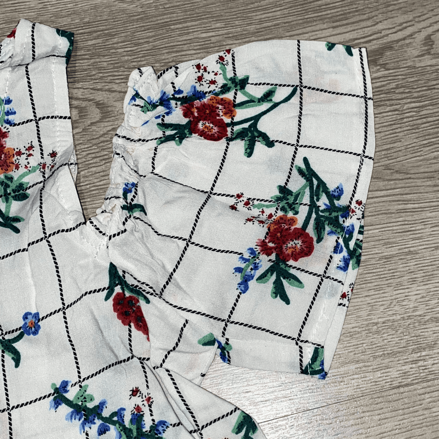 You little one will be ready for a day of fun and learning at school in this white cold shoulder fashion top. This top features ruffle sleeves and a plaid floral print.