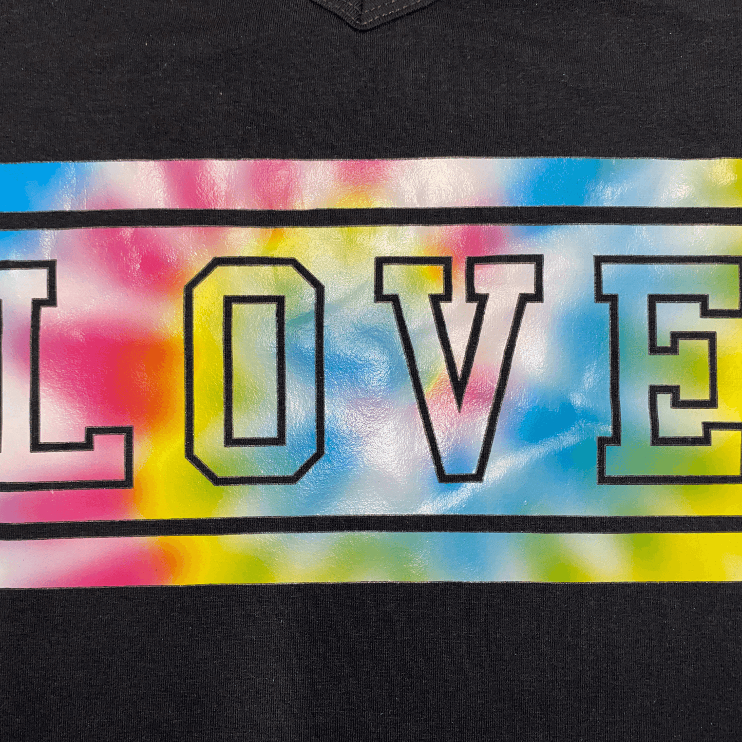 You'll fall in "love" with this graphic T-shirt! This black graphic T-shirt features the word love with a tie-dye background screen printed on the front.