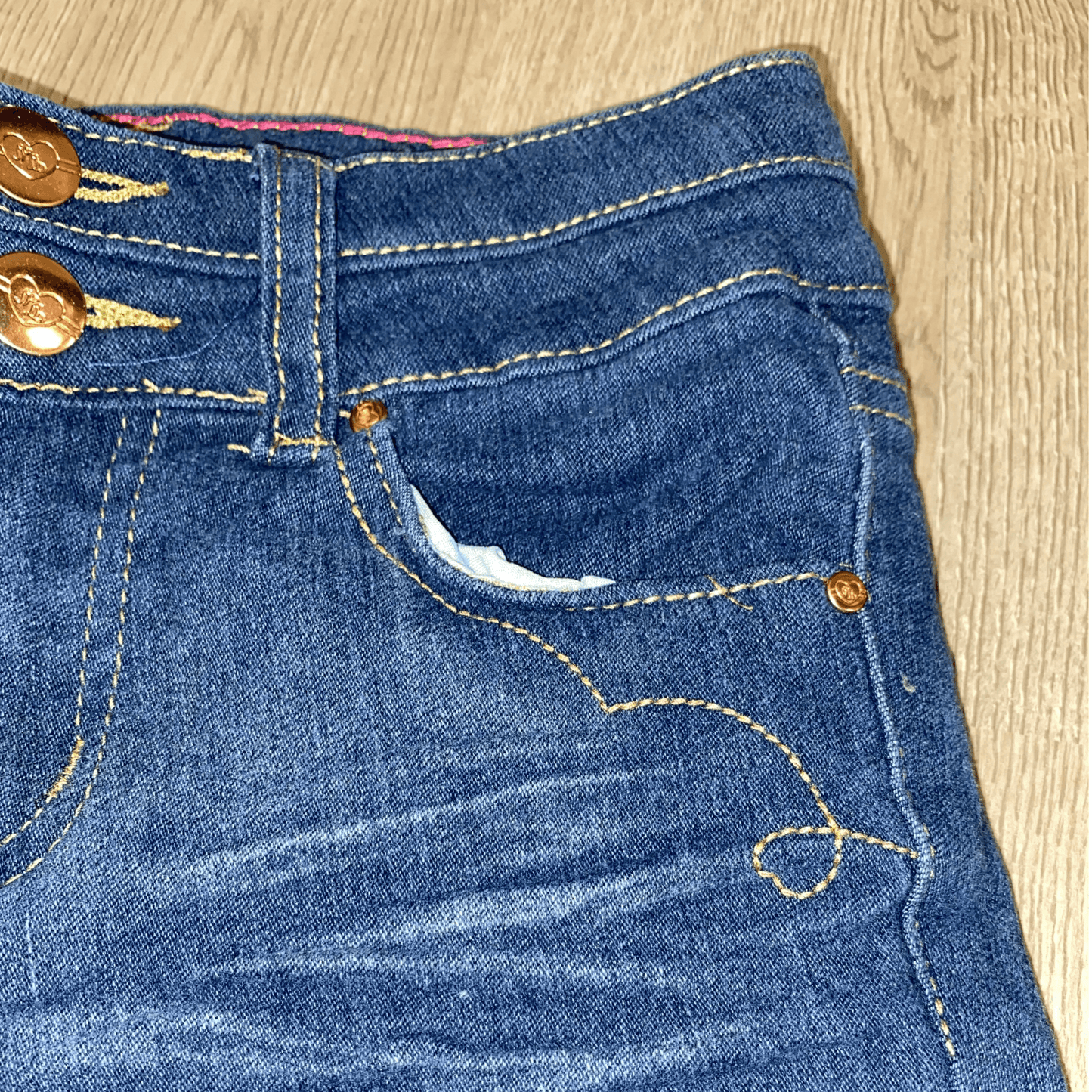 Detailing on the front of the distressed jeans.