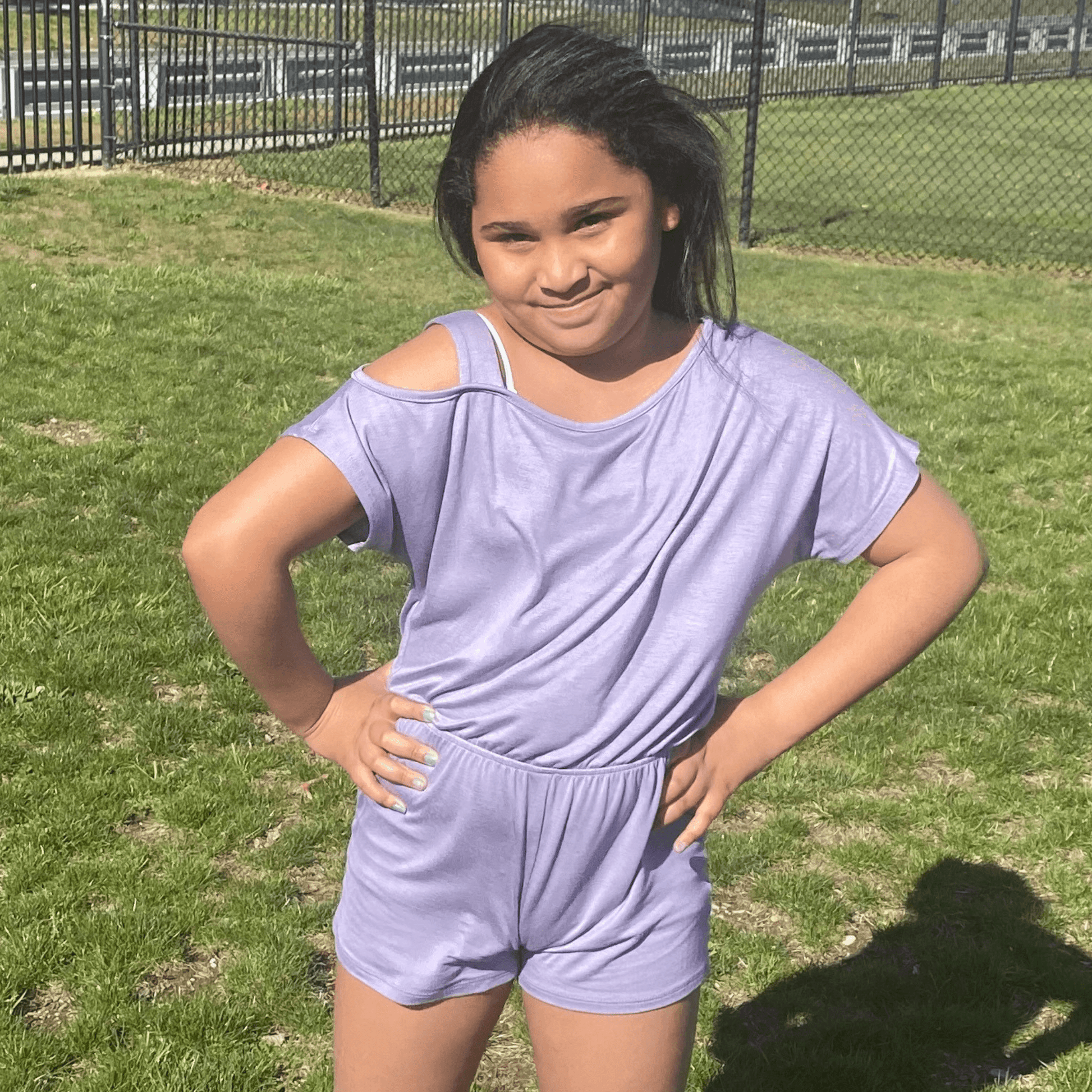 This short sleeve lavender romper features cold shoulder detailing on the left shoulder and an elasticized waist which allows for plenty of movement. 