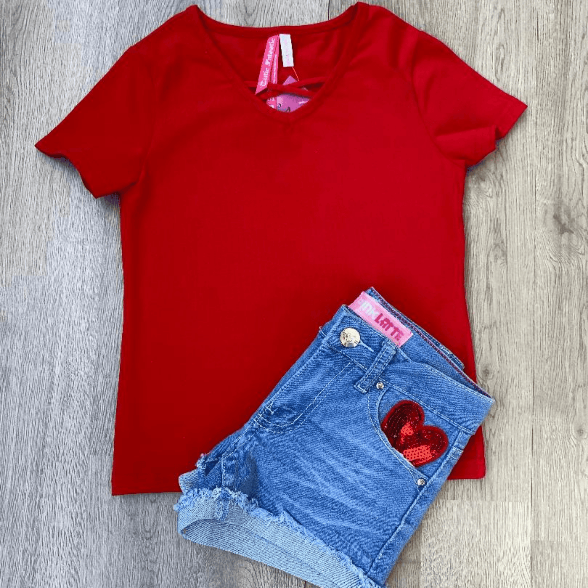 This short set features a short-sleeved red shirt with a criss cross design at the neckline.  The denim shorts feature a sequined heart on both the front and back pockets.  This is an outfit your little fashionista is sure to love.