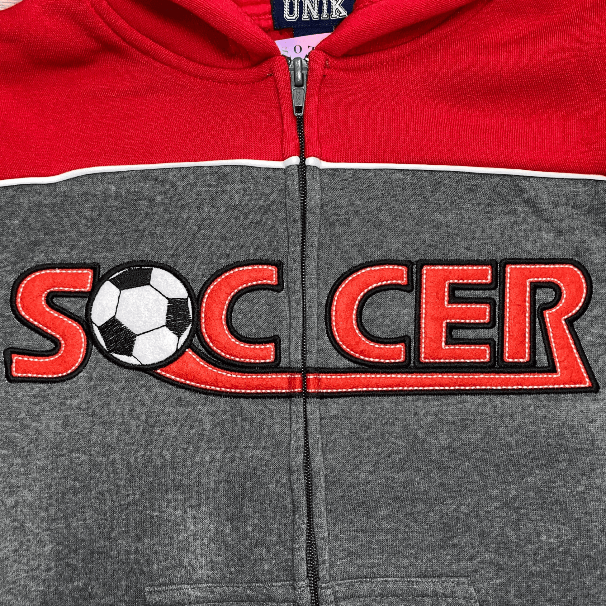 This dark grey soccer fleece set with red trim is perfect for your little soccer fan.  This sweat suit features the soccer logo written with a soccer ball for the letter "o" and thick red stripes down the side of the legs.