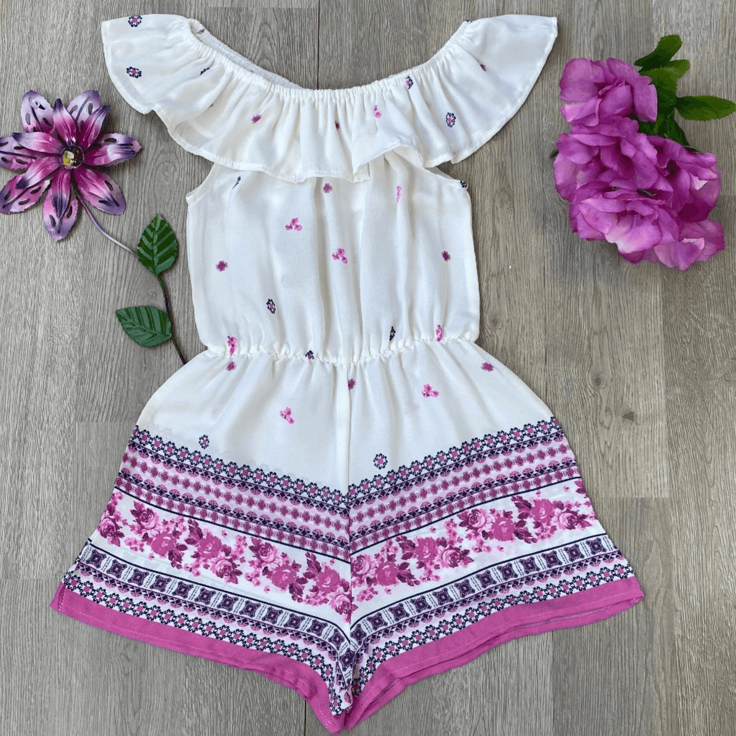 This romper is perfect for a hot, summer day.  With this light weight, white, ruffled peasant neck romper in woven Moroccan crepe with pink border your fashionista will be the most stylish girl around.