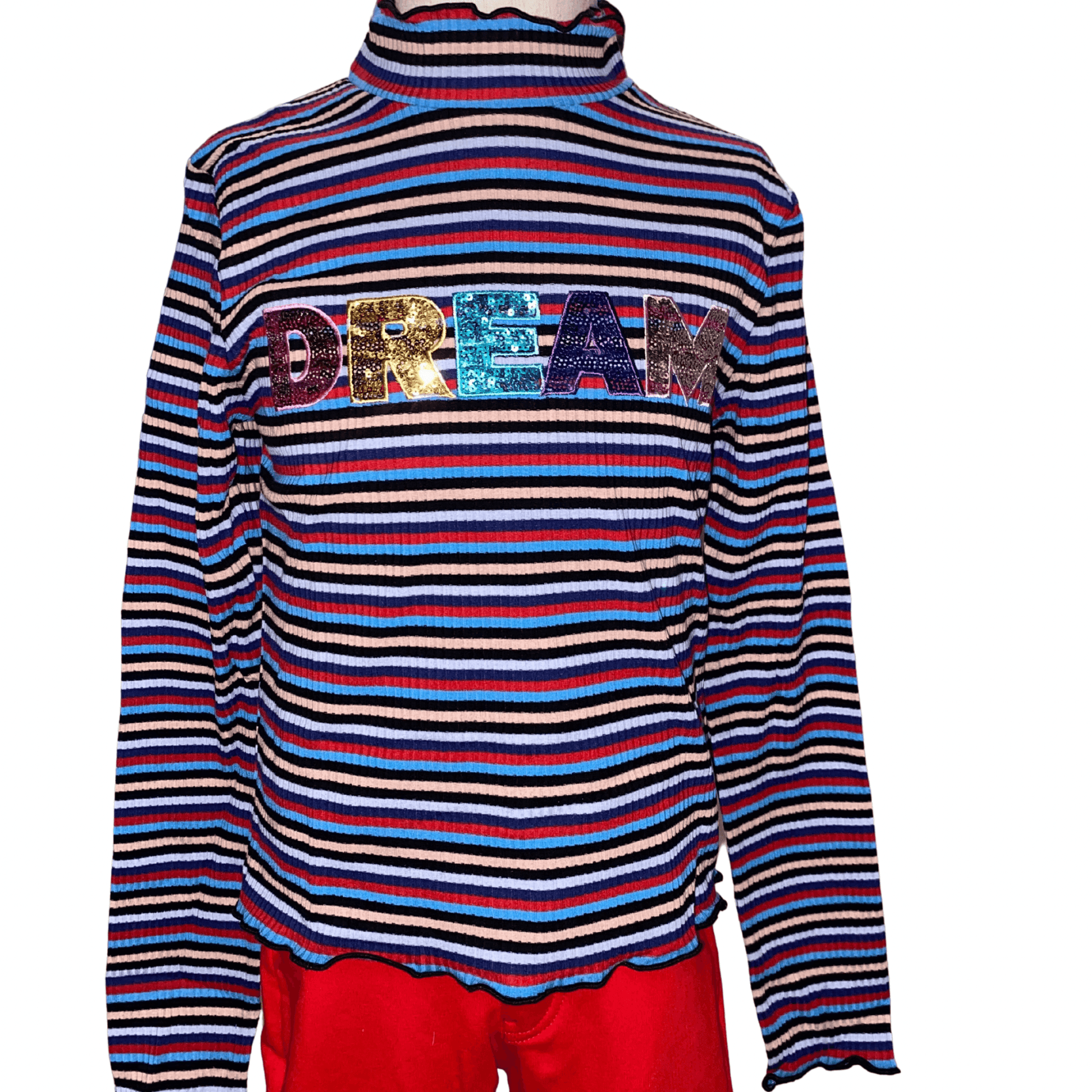 Our ruffle sleeved "DREAM" shirt is a perfect addition to the wardrobe of the little lady in your life.  This shirt features long sleeves and a mock turtle neck with scalloped edges.  This shirt has red, navy, and blue stripes with the word "DREAM" in sequins. 